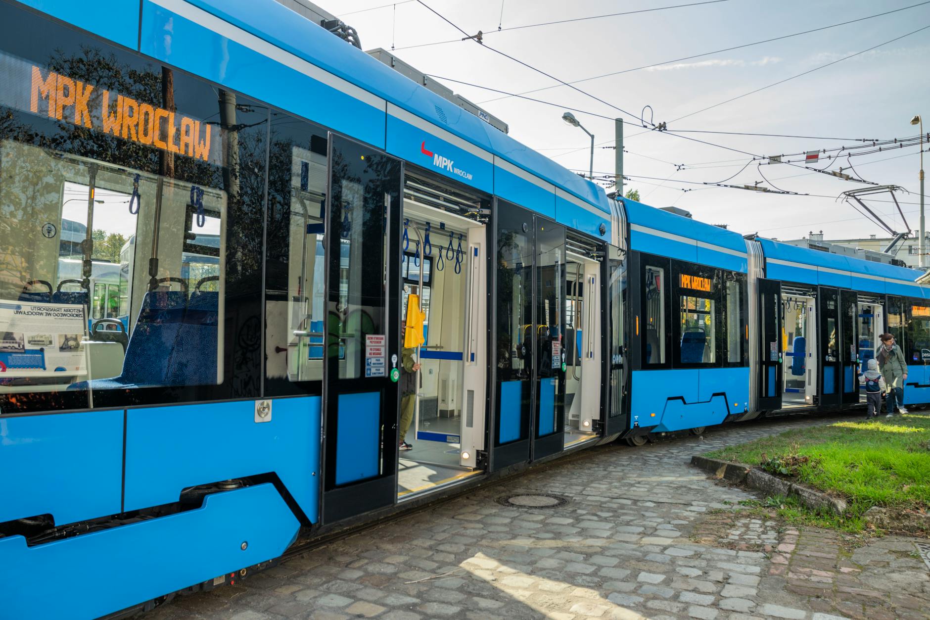 Ilustracja przedstawiająca nowoczesny przystanek autobusowy w Rzeszowie z wyświetlaczem informacyjnym i elementami inteligentnej technologii.